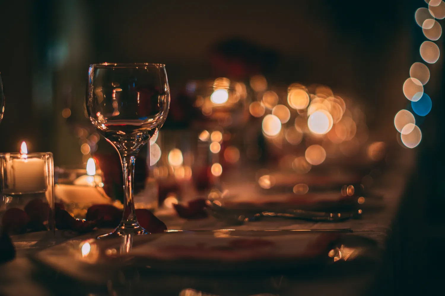 Festlich gedeckte Weihnachtstafel mit Kerzenschein und Weingläsern